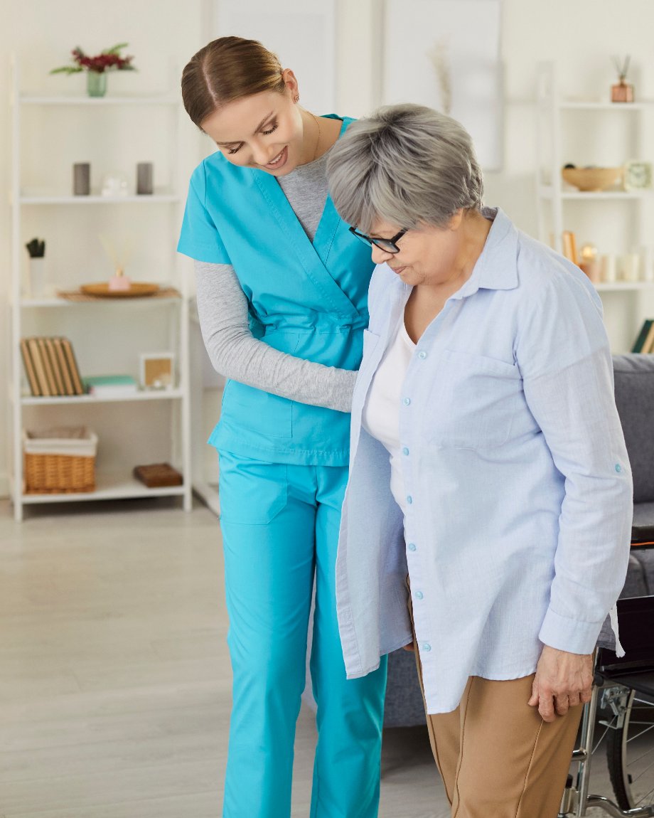 Home health nurse helping a senior patient walk at home